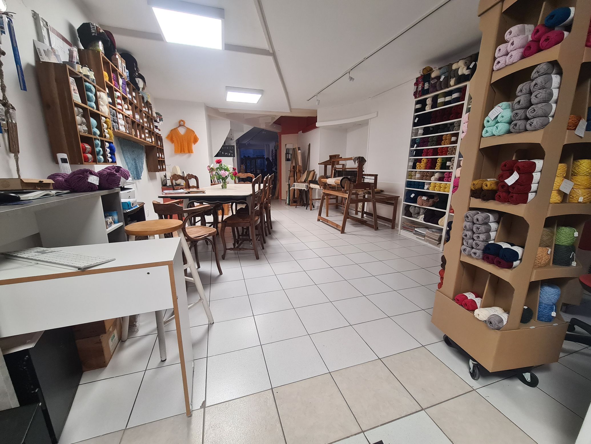 Un métier à tisser avec un travail bariolé en cours et des vètements tricotés à côté