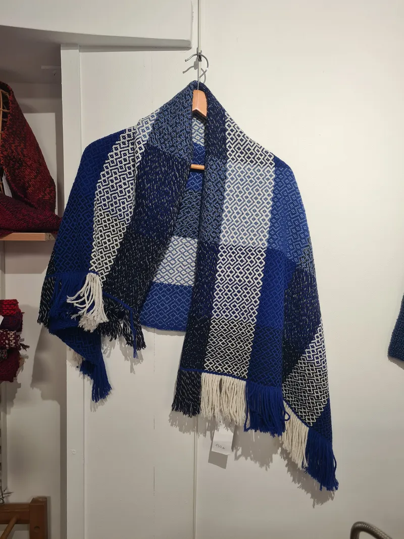 Un poncho bleu et gris au mur